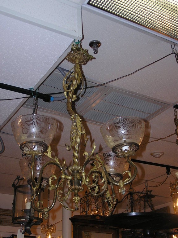 Italian gilt bronze four light gasolier with rope twisted center shaft, floral scrolled arms with original gas keys, and etched glass globes. Chandelier has been electrified. All original.
