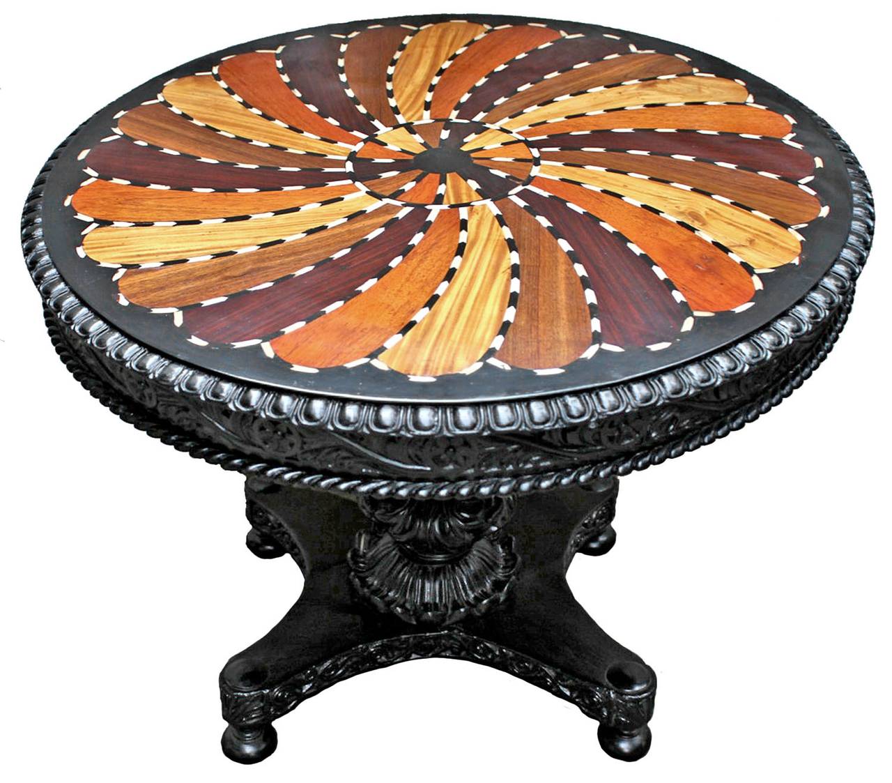 circular tilt-top inlaid with a whorl of specimen veneers including Ivory and Ebony. This style was a specialty of the Galle District of Ceylon which was famous for it's specimen-wood furniture. For further information about furniture from this