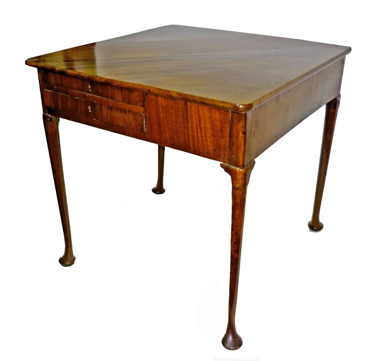 Triangular top with a similar drop raised on a gate-leg; the frieze with two drawers; the whole on turned and tapering legs ending with pad feet.