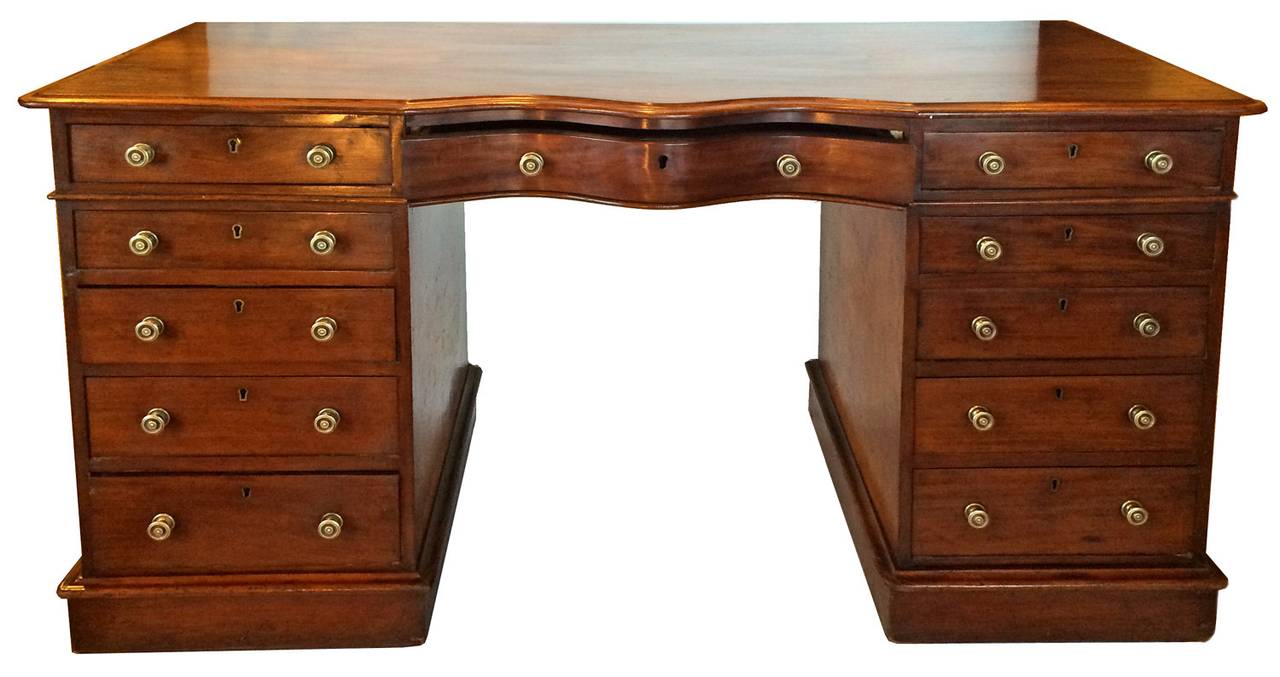 First half of the 19th Century; featuring a serpentine drawer front & molded base with graduating drawers for each pedestal.