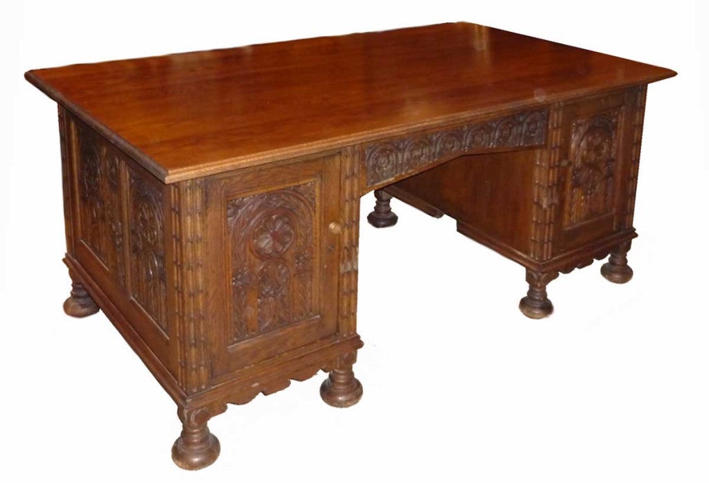 rectangular top over a pair of pedestals with carved oak doors opening to modern fittings; raised on bun feet.