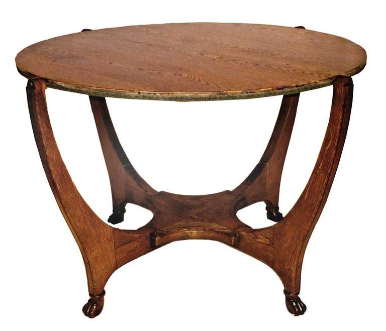 the 40.5 inch circular top with release mechanism which revolves the top to a felt-lined playing surface on the reverse, resting in a yoke with a low shelf and raised on paw feet, brass label on base. Note: Near the end of his life in the 1890s, the