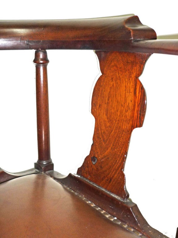with curved crest rail above two molded solid arms with rounded terminals, and supported on three turned uprights with ring and baluster collars and two urn shaped flat figured reticulated splats, the leather upholstered seat rounded at the front