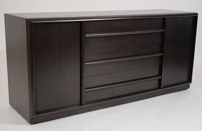 A credenza or cabinet in a dark brown lacquered finish by T. H. Robsjohn-Gibbings for Widdicomb Credenza.