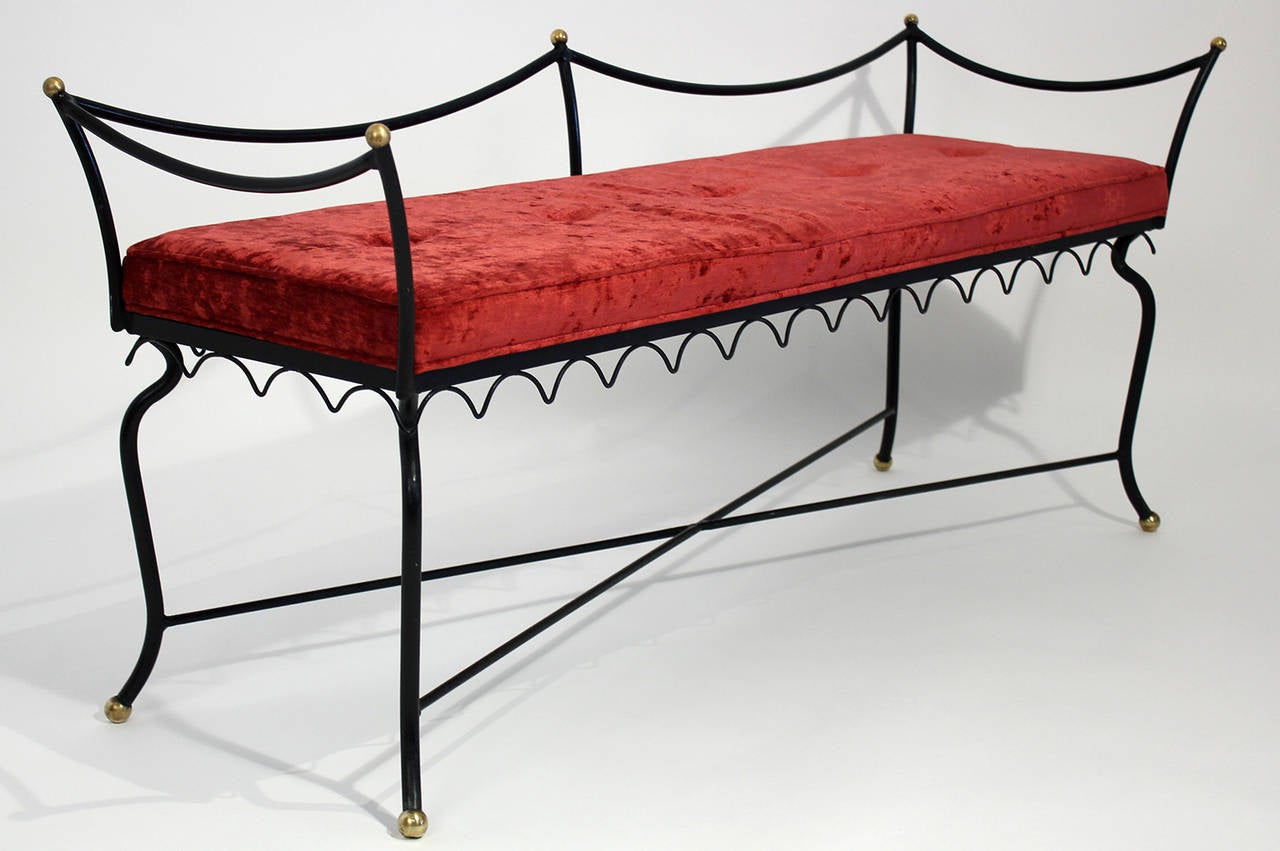 A simple and decorative vintage boudoir style bench of wrought iron with brass accents and finished in red velvet upholstery. Equally useful in the bedroom, entry hall or boutique. Probably French. Gently used original painted finish with new
