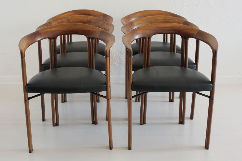 Set of six Ulna chairs by Franco Poli for Bernini constructed of olive wood with wonderful grain throughout. reupholstered in black Italian leather with a satin finish. The wood is in satin as well.

The arm tapers down from 29.25