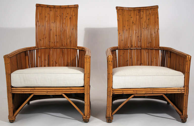 Early pair of modernist art deco rattan lounge chairs with spring seat construction under cushion. Circa 1930s. Chairs are in excellent vintage condition showing only minimal signs of wear with new fabric and foam cushions.