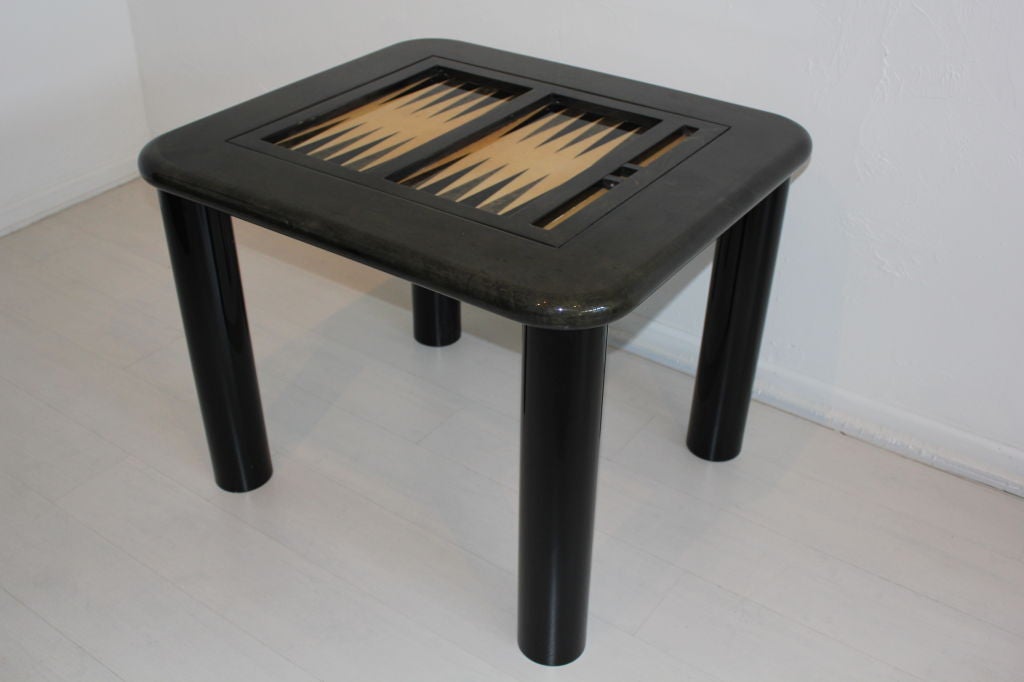 Lacquered Goatskin Backgammon Game Table by Aldo Tura. Legs are lacquered black. Top is a dark Grey leather. The center flips to hide the backgammon board and be used as a table. Table is in very nice condition. The very bottom of the legs show a