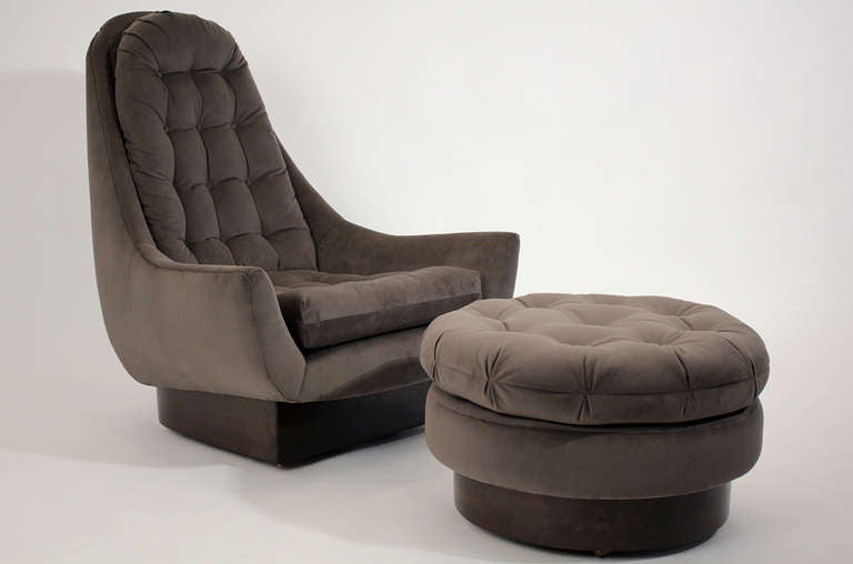 An extremely comfortable and sculptural high back swiveling lounge chair with rolling ottoman. Completely restored with new foam and fabric. Upholstered in  a dark gunmetal green velvet. Very much in the manner of Milo Baughman or Adrian