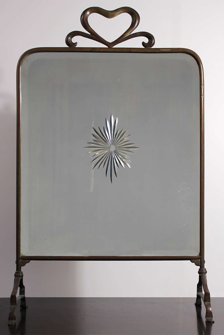 Charming Art Deco brass framed fire screen mirror with etched glass embellishment. Wonderful vintage patina and minor imperfections in glass as pictured. Dated on back. Can also be used as a table or vanity mirror.