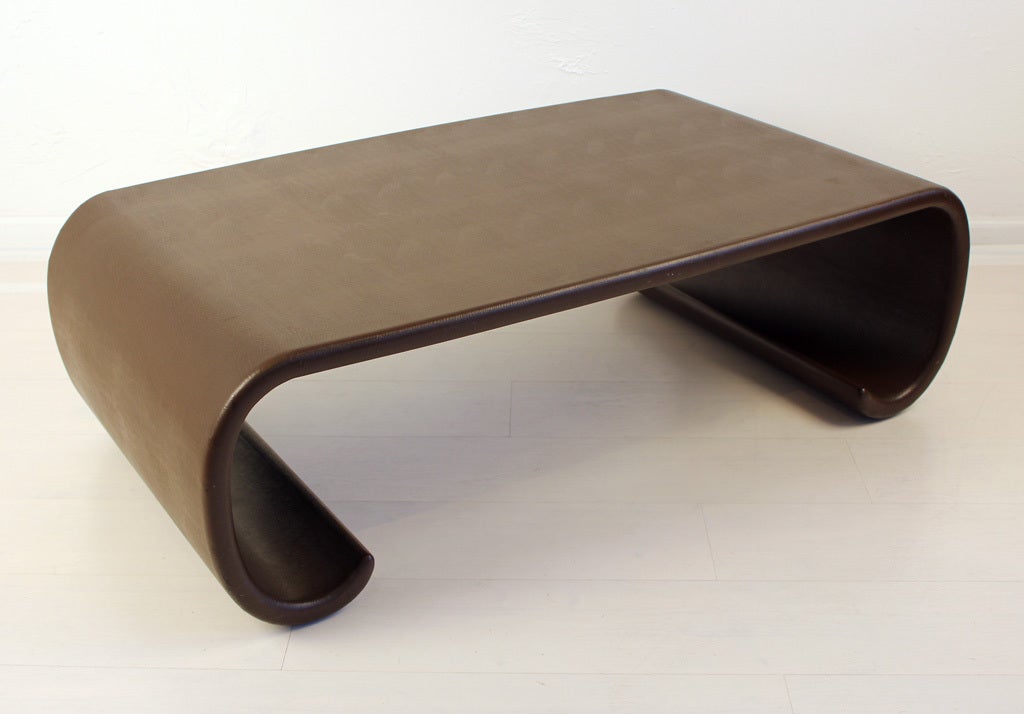 A dark brown Asian scroll coffee table wrapped in leather by Karl Springer. Piece is signed on the underside.