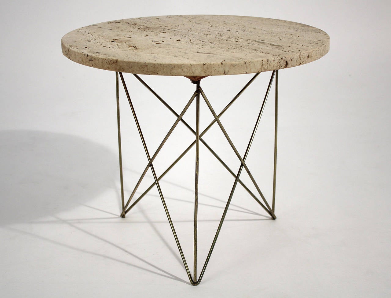 Versatile small scale side table with wire strut base and round travertine top designed and made by California designer Rene Brancusi, circa 1950s.