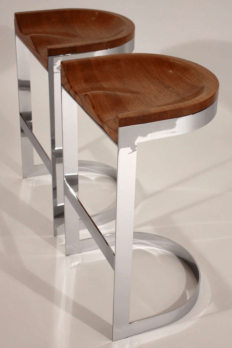 Expertly crafted pair of bar stools in solid chromed steel with carved solid oak formed seat top designed by Warren Bacon.

Each chair measures 28