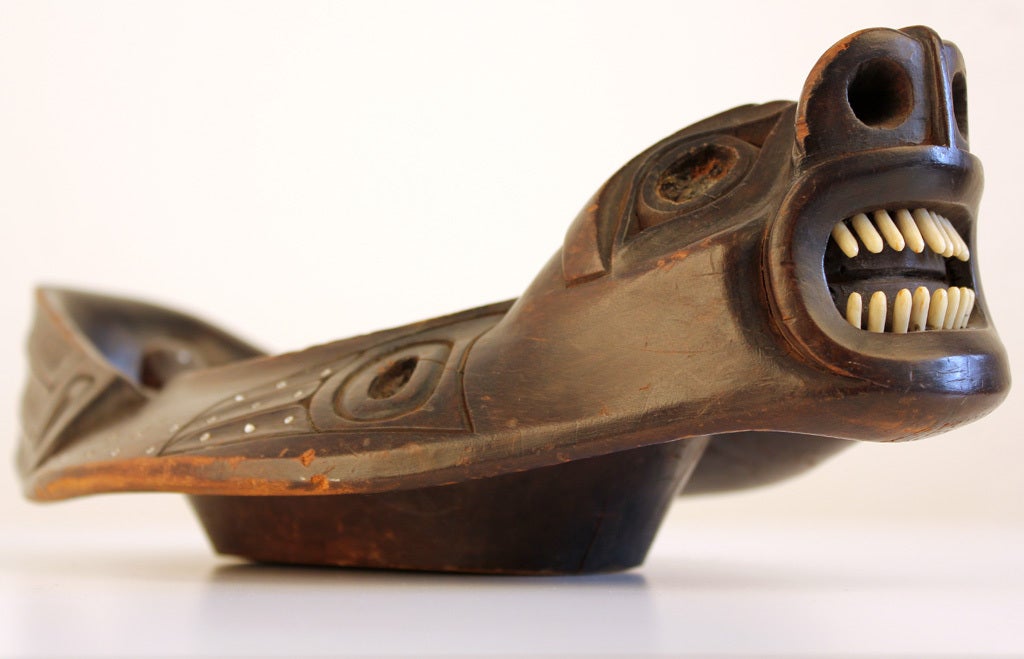 Northwest Coast Haida Tribe carved wood bowl. This is a prized piece carved in the form of a seal with walrus ivory teeth, inset oval ivory discs and shell inlay throughout. This piece was used on special occasions to serve eulachon or seal oil.