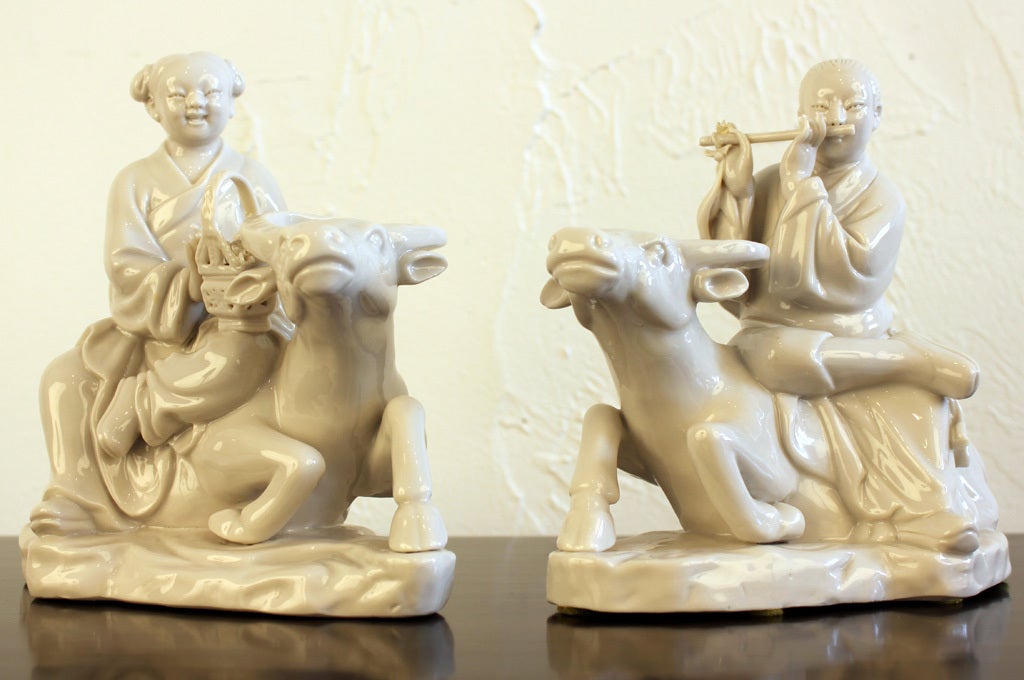 Pair of Chinese blanc de chine porcelain figurines of a man and woman on a water buffalo designed by Maitland-Smith. Retains original labels as pictured. Measurements are for each piece.