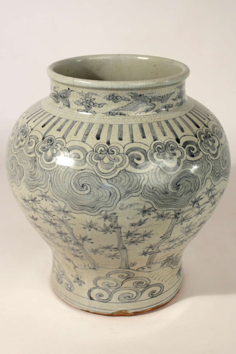 A fine old Korean blue and white porcelain jar. Finished with an even transparent glaze and craquelure throughout. Cylindrical base, massive shoulders with upright rim. Hairline to rim as pictured.
