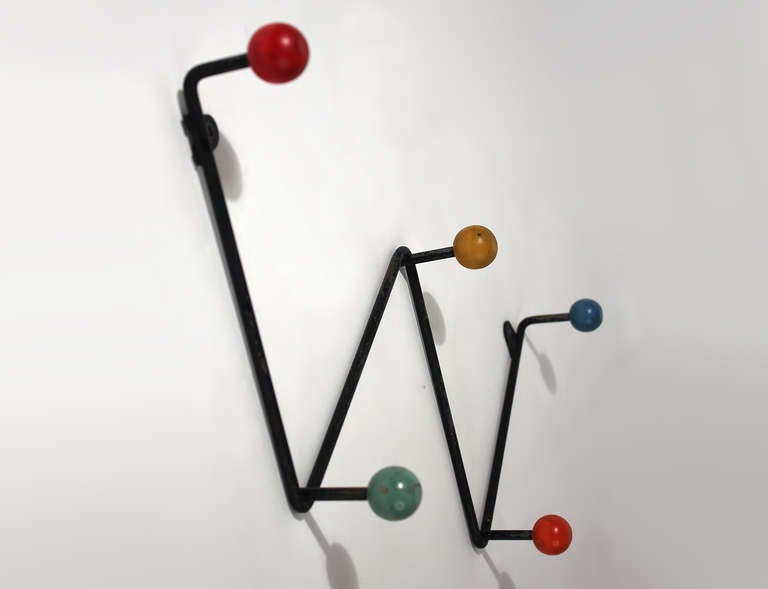 A charming minimalist Eames Hang-It-All style iron wall mounted coat hanger with painted wood ball hooks. Probably french. All original painted surface with a nicely well-used patina as pictured.
