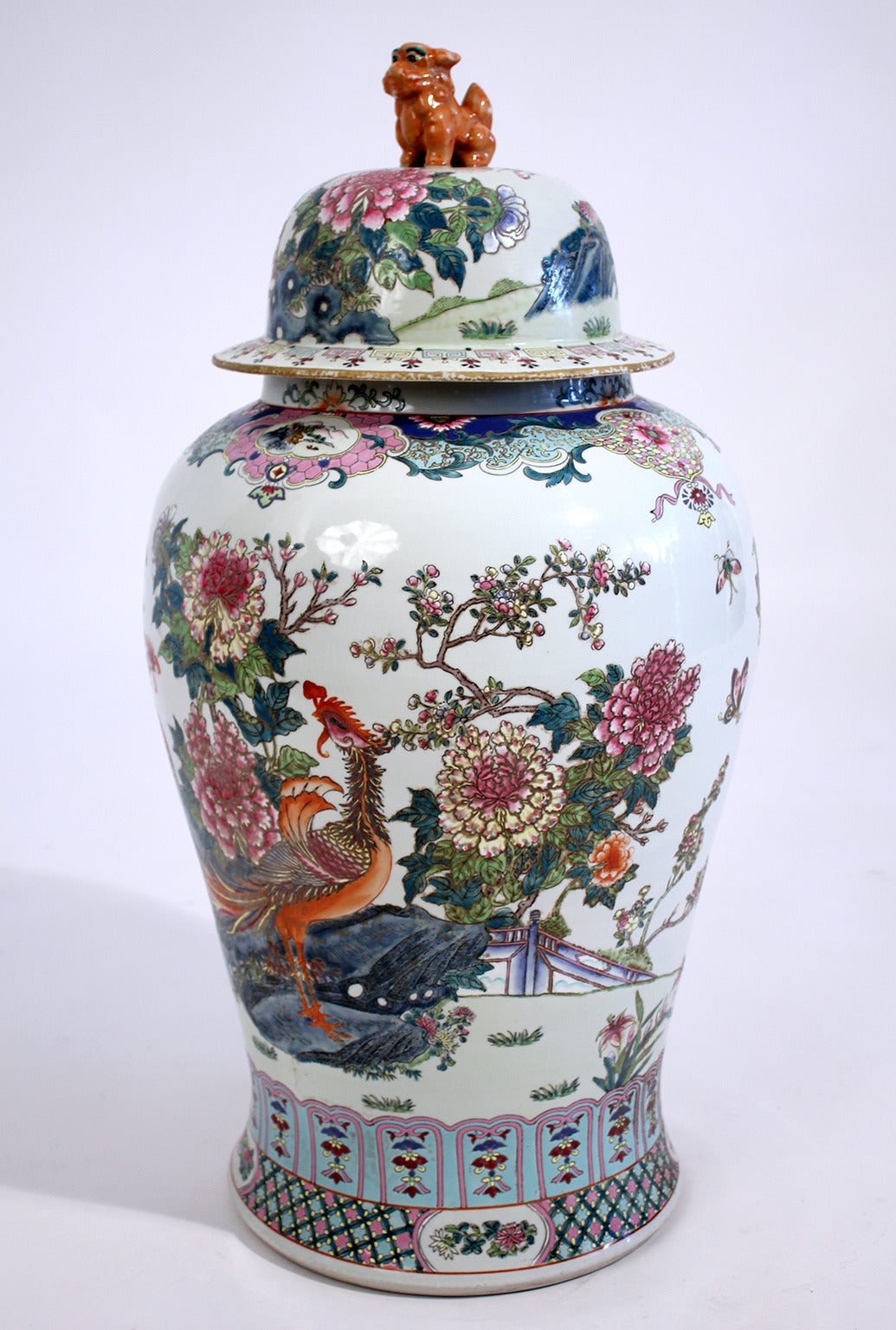 Large Chinese porcelain enamel painted lidded floor vase with mythic phoenix birds and chrysanthemum floral decoration. Figural lion dog top handle.