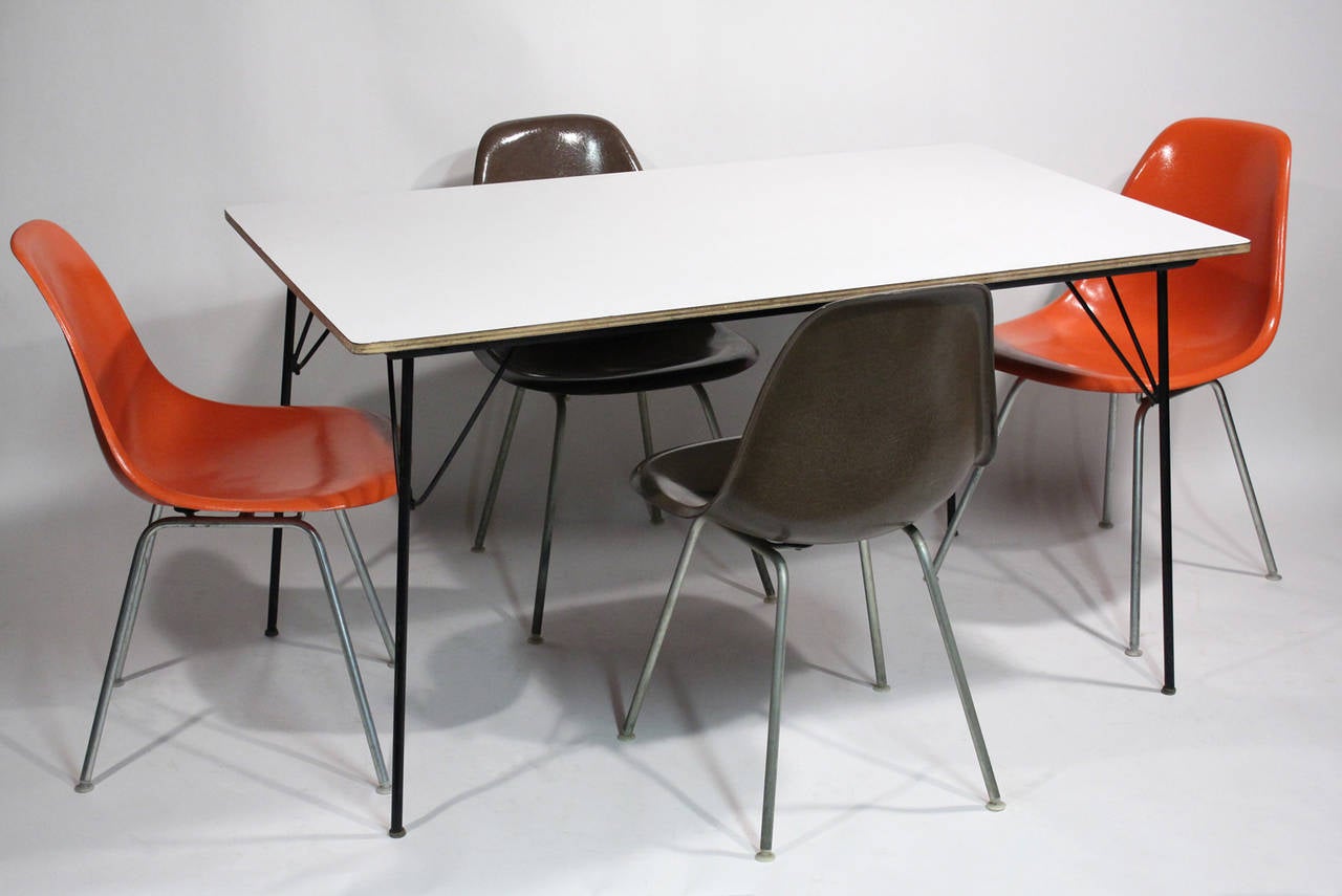 Charles and Ray Eames for Herman Miller. Vintage DTM-10 (Dining-table-metal base) and four fiberglass shell chairs (two orange, two brown). All pieces are purposefully left in original vintage condition with expected age related patina and general