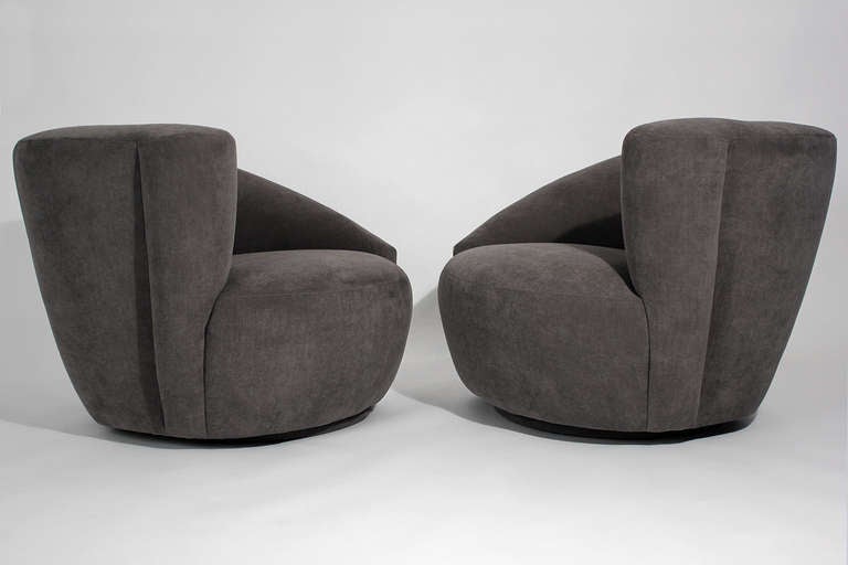 Pair of Nautilus swivel lounge or club chairs by Vladimir Kagan for Directional upholstered in a smooth dark grey subtly textured velvet fabric.