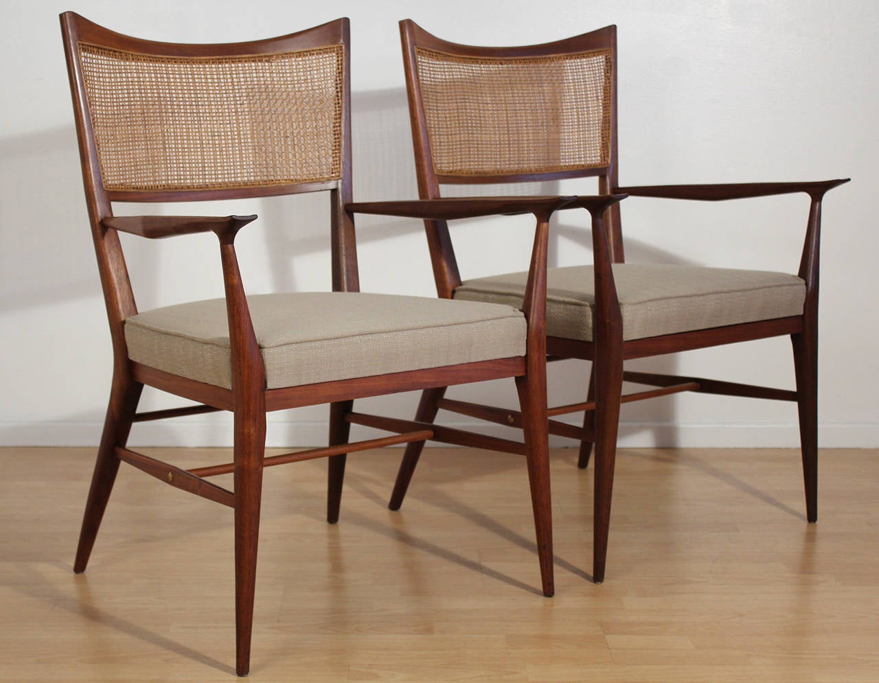 Elegant modernist pair of occasional armchairs or side chairs with cane backs designed by Paul McCobb. This pair is larger than the similar 