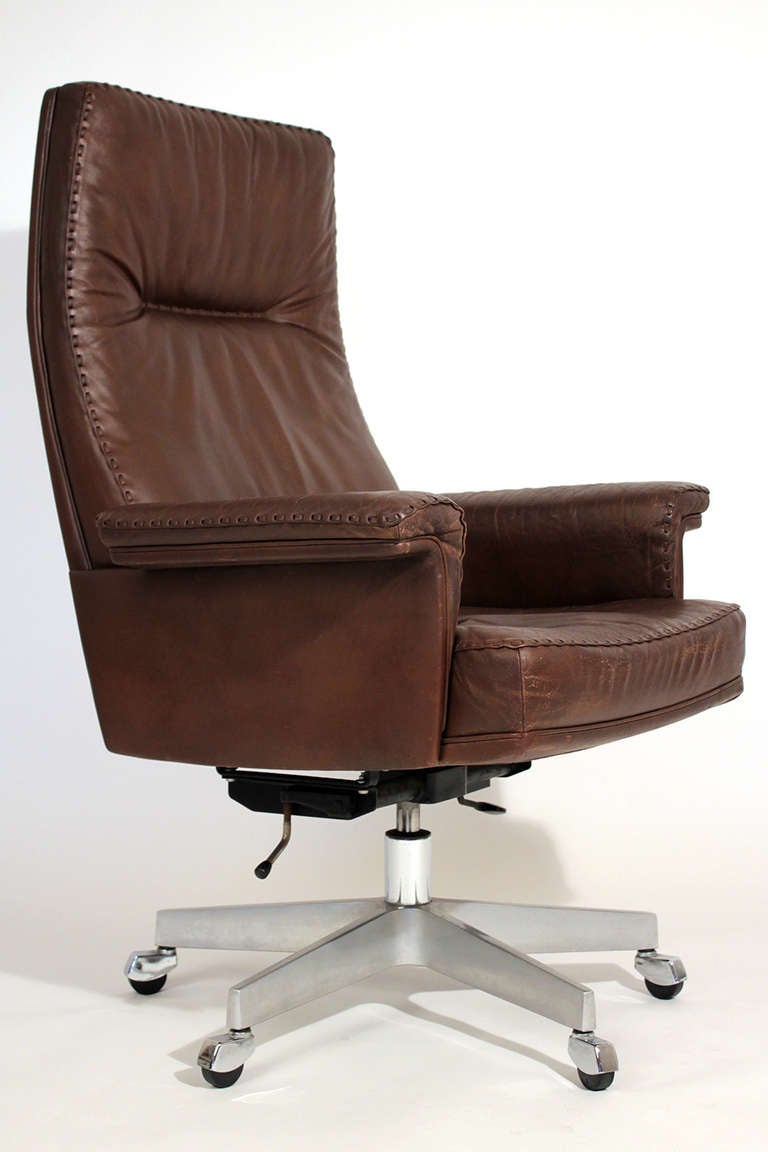 Brown leather executive swivel chair on casters manufactured by De Sede, Switzerland.