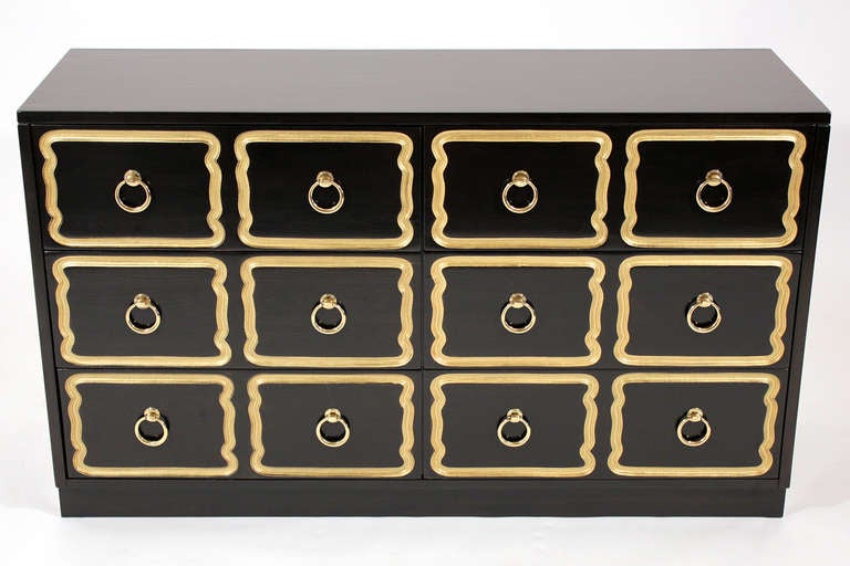 Dorothy Draper designed chest of drawers or dresser. Black lacquered and gold colored finish with brass finished pulls.
