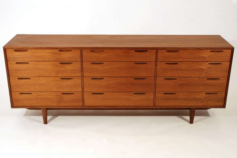 A beautifully constructed teak Danish modern 12-drawer dresser with finished back.