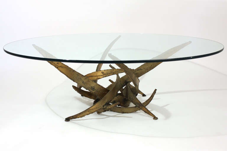 Brutalist style glass top coffee or cocktail table of welded steel with a gold finish in the manner of Daniel Gluck or Silas Seandel. 48