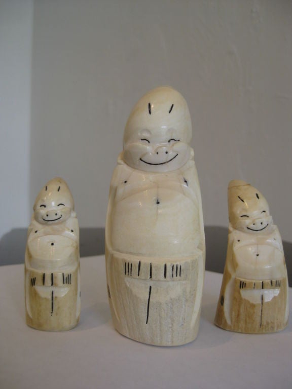 Group of three carved Ivory billiken figures. These were carved as souvenirs by the Inuit people of Alask. The largest measures 4 3/8