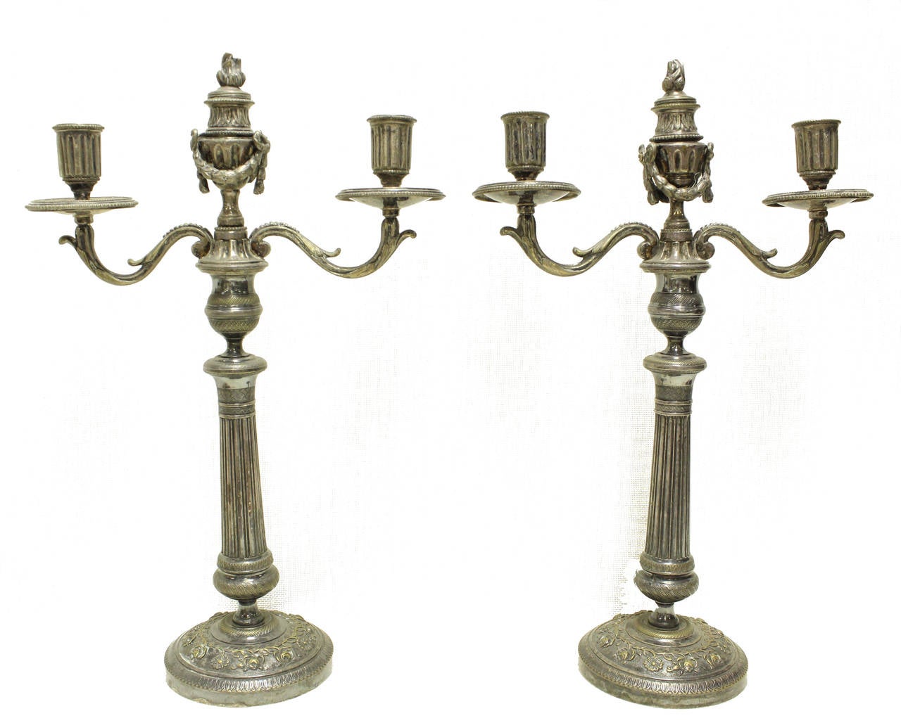 Stunning pair of silver plated candelabras with detailed foliage, reeded center, flame top and foliate swag.