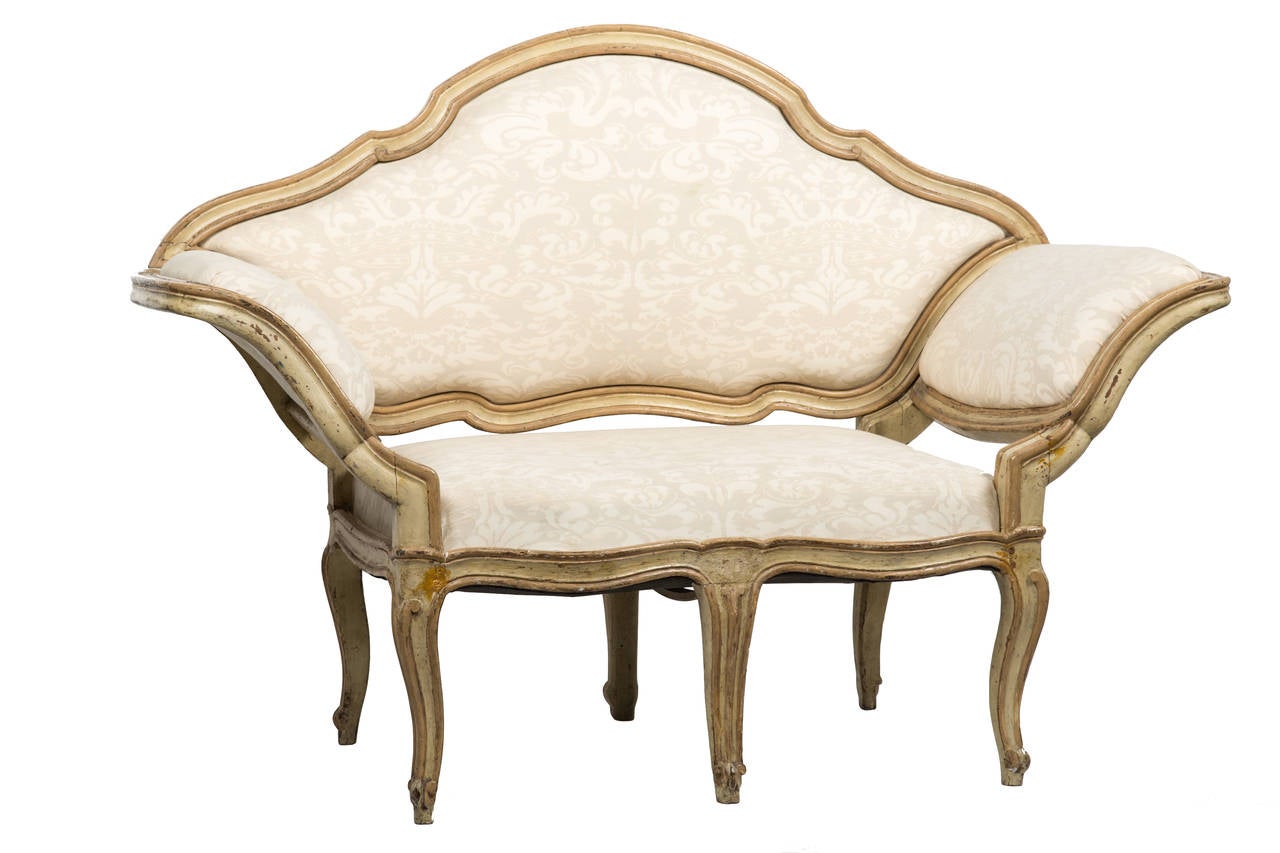 Tara Shaw Antiques - Lovely antique Italian settee with Venetian rococo shaped back that is detachable. The cabriolet legs and ornately carved wood frame has warm antique patina. The fabric featured is a soft beige and cream colored corona pattern