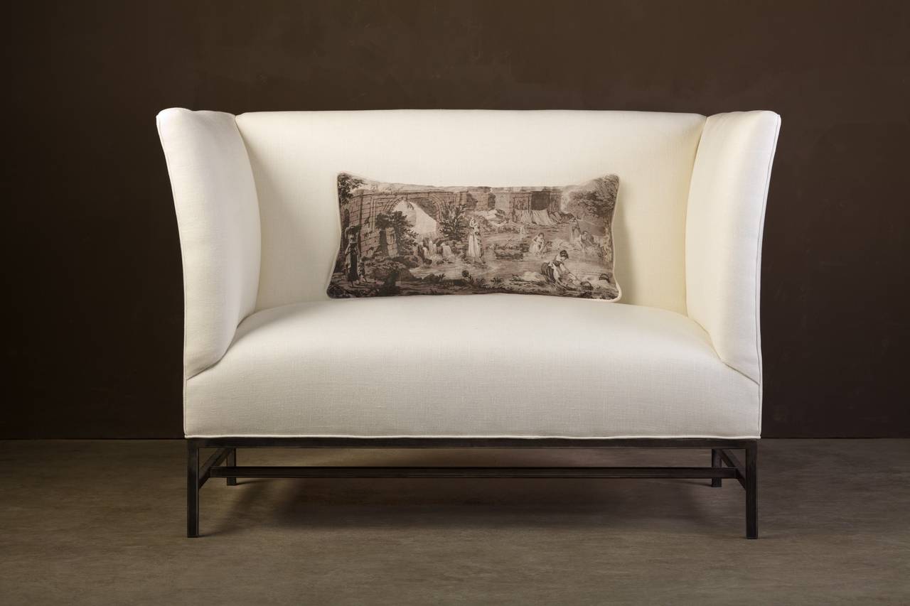 This streamlined settee from the custom Tara Shaw Maison collection has height-enhancing proportions on a forged iron base. Handcrafted in New Orleans. Standard loveseat upholstered in an oyster heavyweight Belgian linen.

Custom dimensions, finish