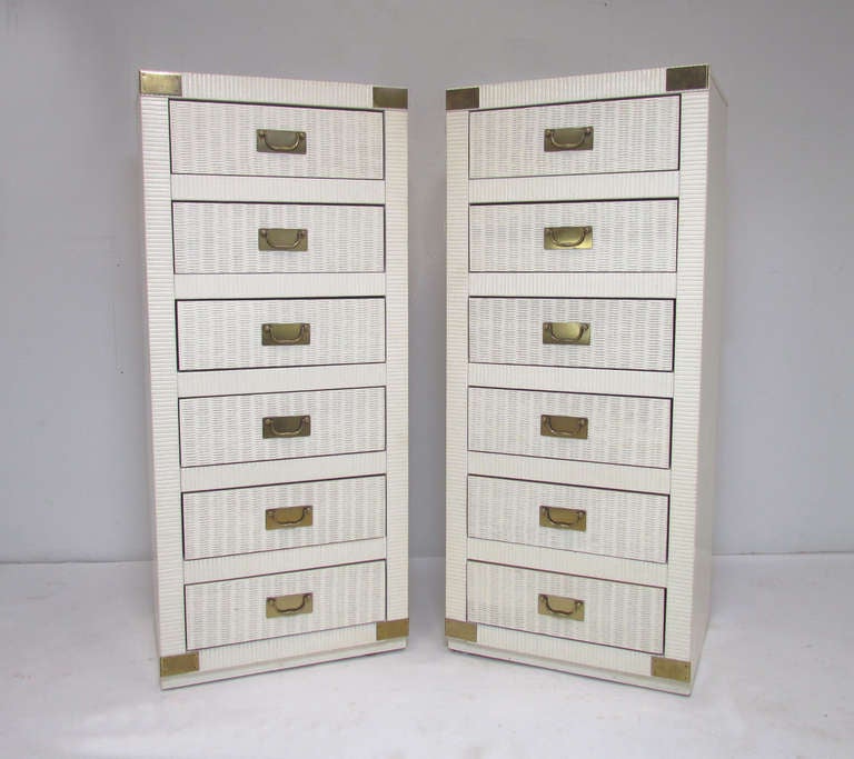 Matching pair of campaign style tall six-drawer dressers in original  
white lacquer. Drawer fronts in attractive basket weave reeding with  
brass backplates and handles.