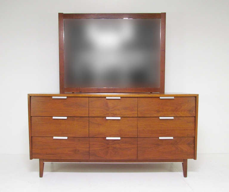 Mid-century modern nine-drawer dresser with brushed aluminum pulls, and matching mirror (mounts to back of dresser if desired or to the wall).  By Cavalier, ca. 1960s.

Cavalier was a high quality American furniture maker best known for the