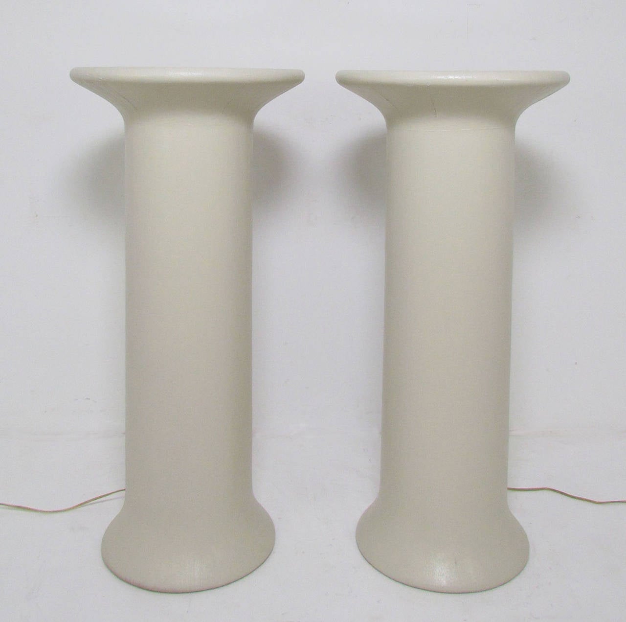Pair of columnar lighted display pedestals in lacquered linen with frosted glass tops, circa 1970s.