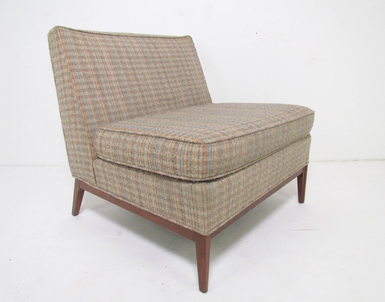Generously proportioned Mid-Century Modern slipper lounge chair with walnut base attributed to Paul McCobb, circa 1960s.