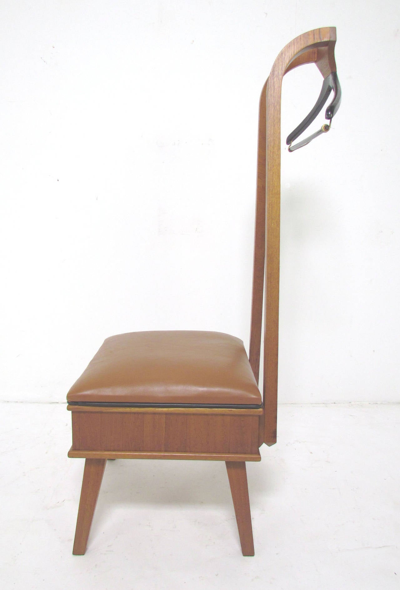 Handmade Mid-Century Modern valet chair in walnut and teak with a leather seat and integrated hanger for a gentleman's suit, apparently signed 