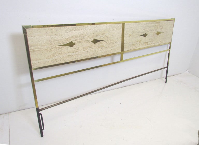 Glamorous headboard for a king size bed, ca. early 1960s.  Solid brass frame with polished travertine panels, inlaid with ornamental brass darts.  In the manner of Mastercraft, possibly made in Italy.