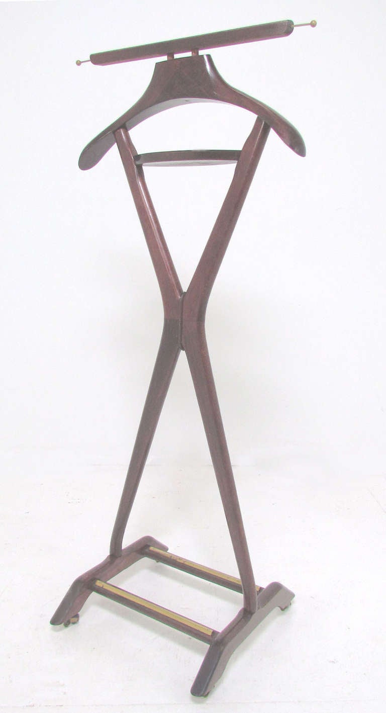 Classic gentleman's valet stand in  original chestnut finish designed by Ico Parisi for Fratelli Reguitti, Italy, ca. 1960s. Includes coat hanger, top rail to drape pants, telescoping rods for ties, and a tray for pocket  accessories, Shoes can be