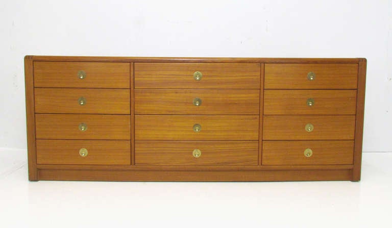 Danish teak mid-century modern chest of drawers with hinged brass finger pulls, twelve drawers, ca. late 1970s.