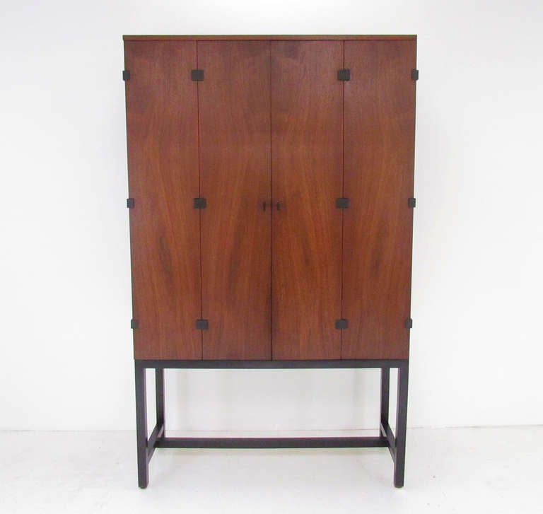 Rare mid-century modern tall sideboard designed by Milo Baughman for Directional, manufactured by Johnson Furniture co., ca. mid-1960s. Walnut case with contrasting ebonized base. This unusual tall credenza also features black anodized metal