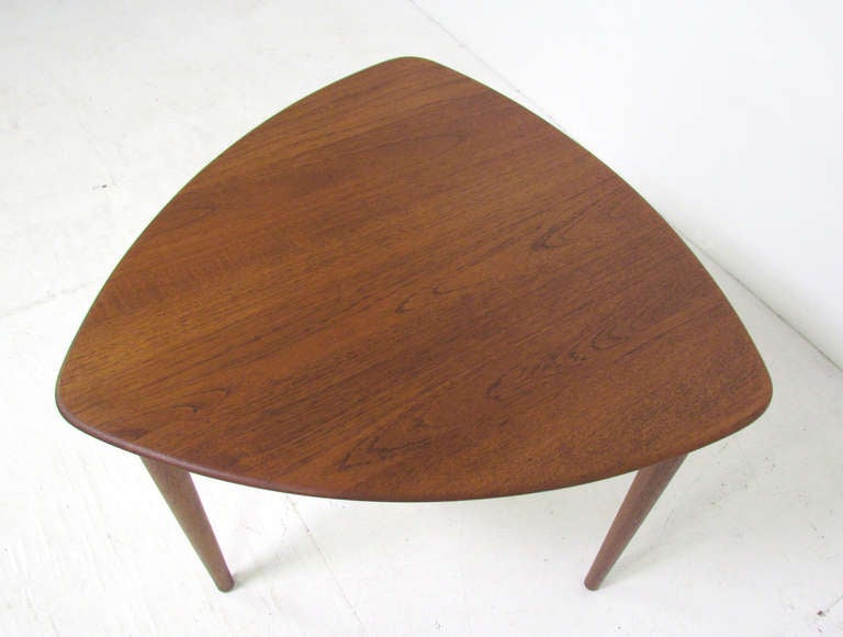 Sturdy teak tripod end or accent table with guitar pick or wedge shaped top, made in Norway, ca. mid 1950s, by Fredrik Kayser for Vatne.   The top is carved from solid teak.