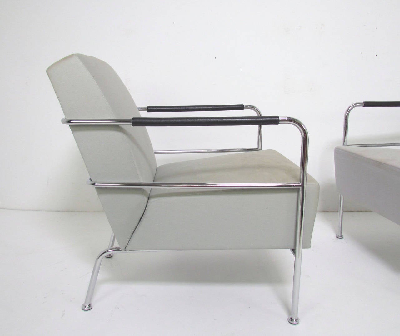Pair of Mid-Century 1970s lounge chairs in a Bauhaus influenced style, chromed steel frames with leather wrapped armrests and flared back legs. Although unsigned, these chairs, which were used for many years in a graphic design firm, were believed