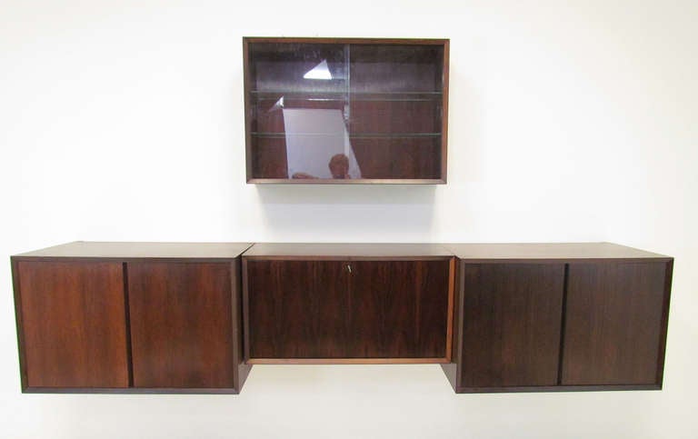 Danish rosewood wall mounted cabinets by Poul Cadovius, ca. 1960s.  Consists of three cabinet units that hang sideboard style 94.75