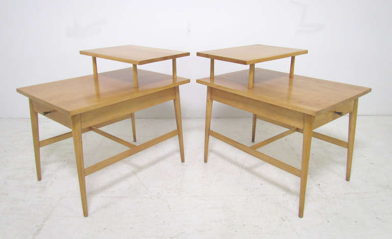 Pair of two-tiered step end tables by Paul McCobb for Planner Group, Winchendon Furniture, ca. 1960s.   With classic McCobb golf tee pulls on the single drawers.