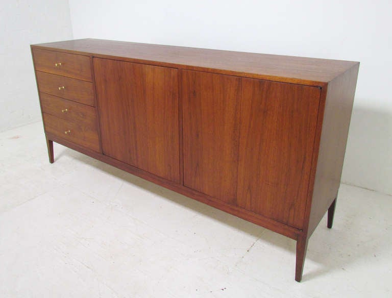 Long low credenza-style chest of drawers in walnut by Paul McCobb for Planner Group, Winchendon Furniture, ca. 1960s.  This dresser, at 6 feet long, is the size of a typical sideboard so can be used as such if drawer style storage is desired. 