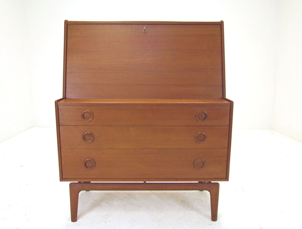 Danish teak secretary desk with underside consisting of a chest of drawers. Floats atop a carved sculptural base.  Unusual carved saucer pulls.  Designed by Arne Hovmand-Olsen for Mogens Kold, Denmark, ca. 1960s