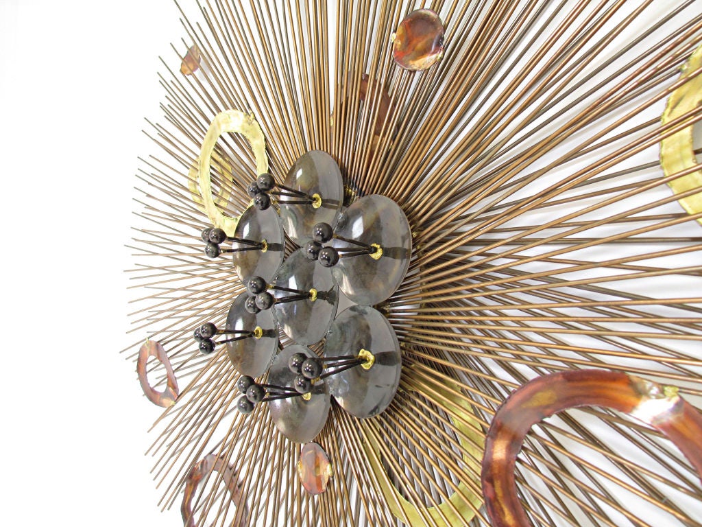 Large starburst metal work wall sculpture in the manner of Curtis Jere, with radiating rods, applied brass and copper elements, and bronze 