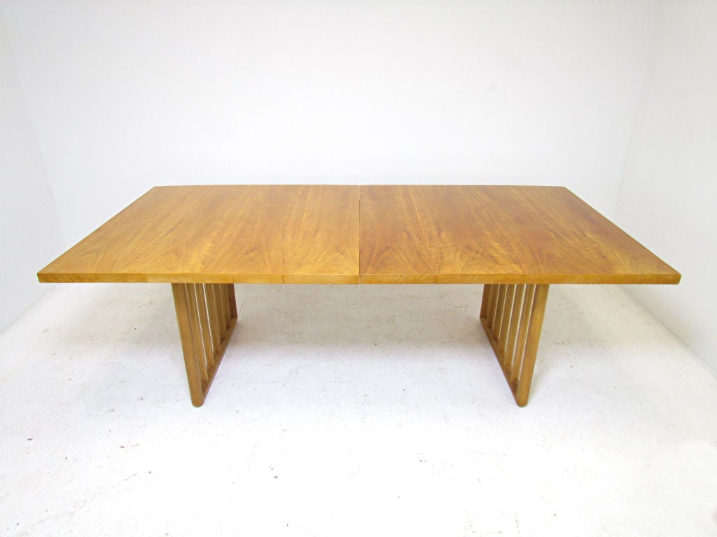Substantial mid-century modern dining table designed by Th. Robsjohn-Gibbins for Widdicomb, ca. 1950s.  In original bleached mahogany finish, with two 16